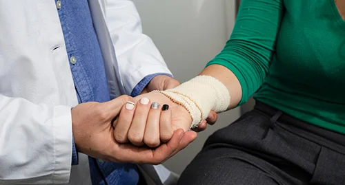 A doctor looking over a bandage on a patient.