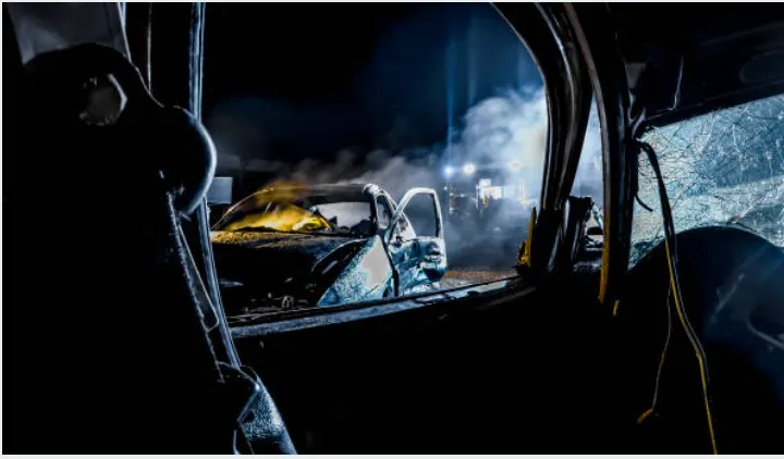 A car after it's been in an accident at night. 