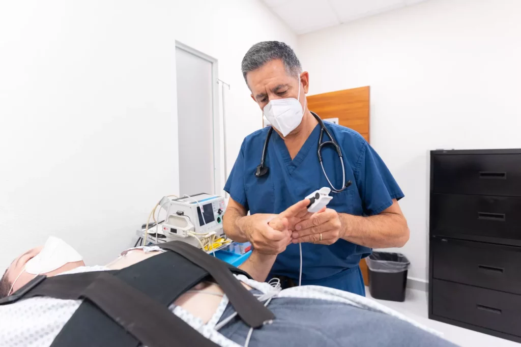 A doctor is running tests and monitoring a patient.