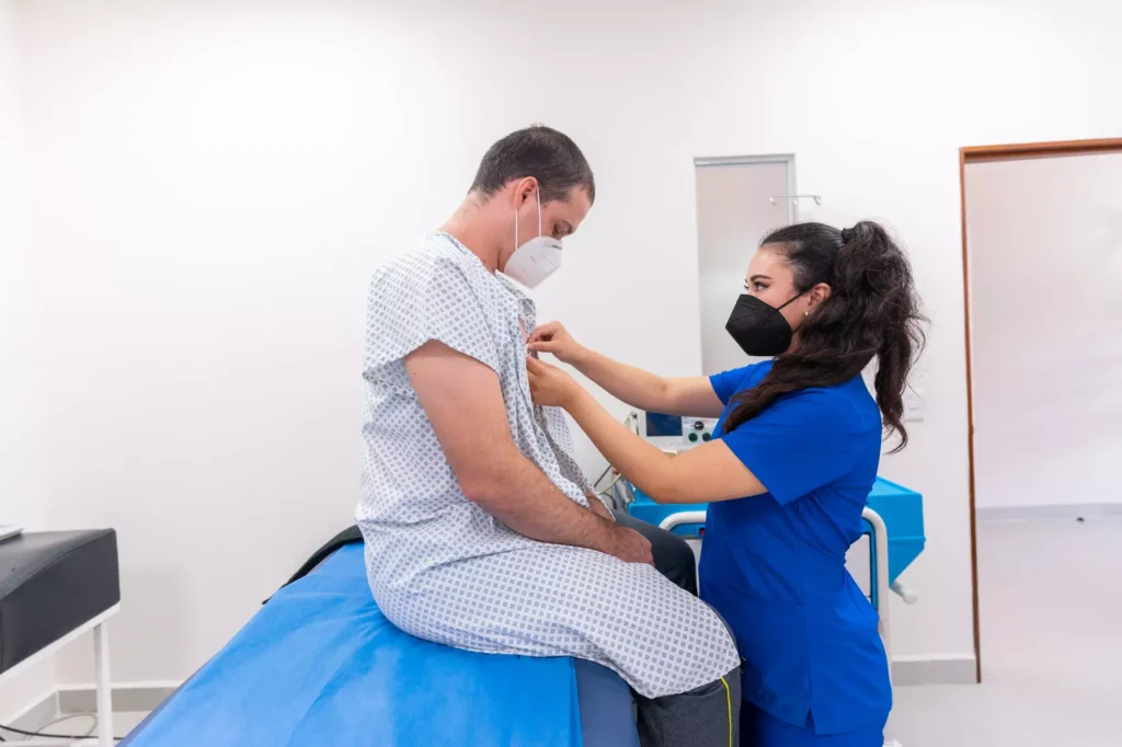 A doctor giving an exam to an injured man in the doctor's office.