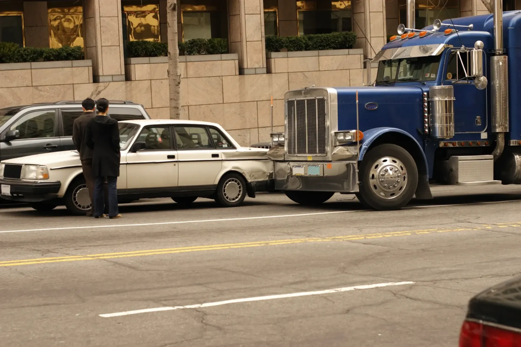 A semi truck hitting a car from behind.