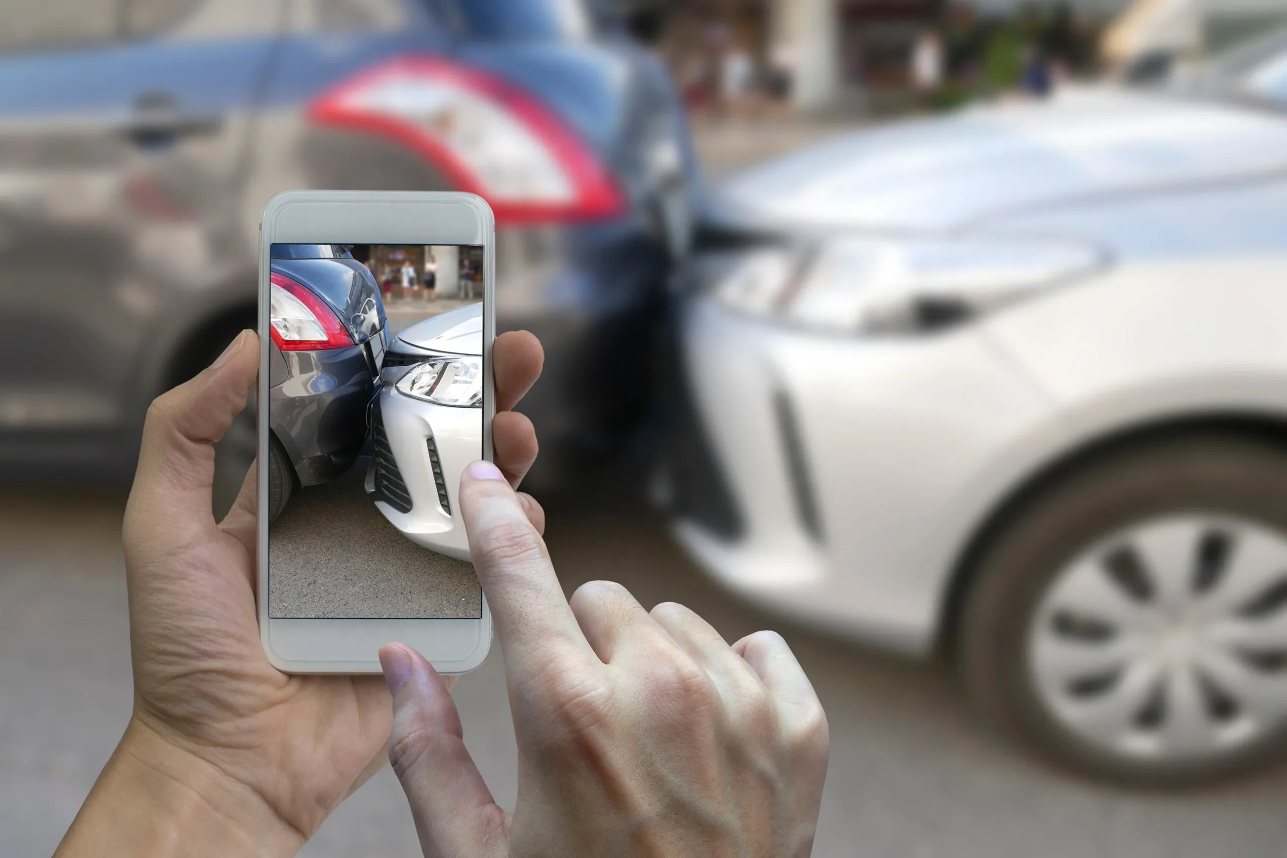 A person taking a photo of a rear-end car accident.