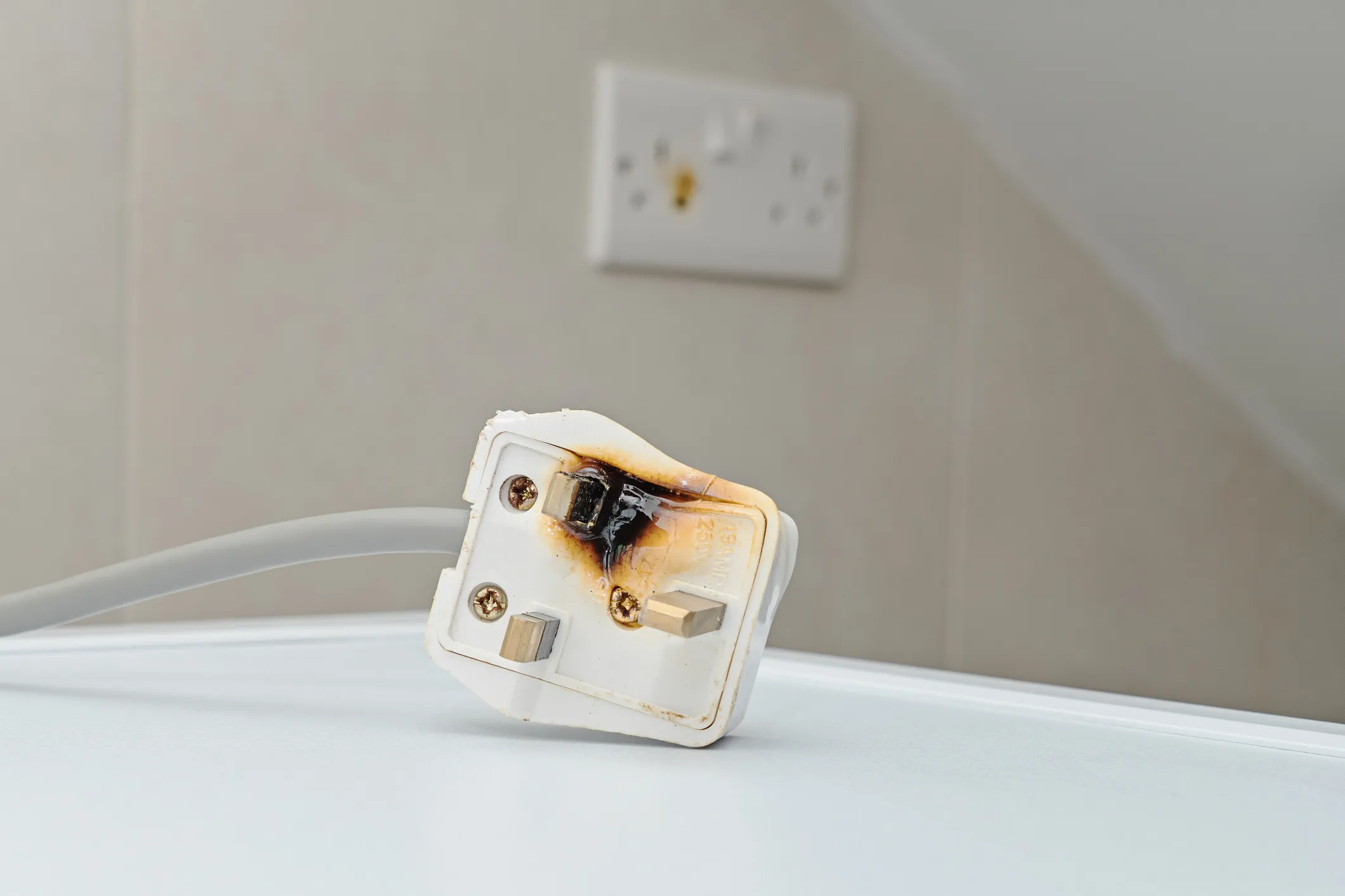 A defective appliance plug, partially burned.