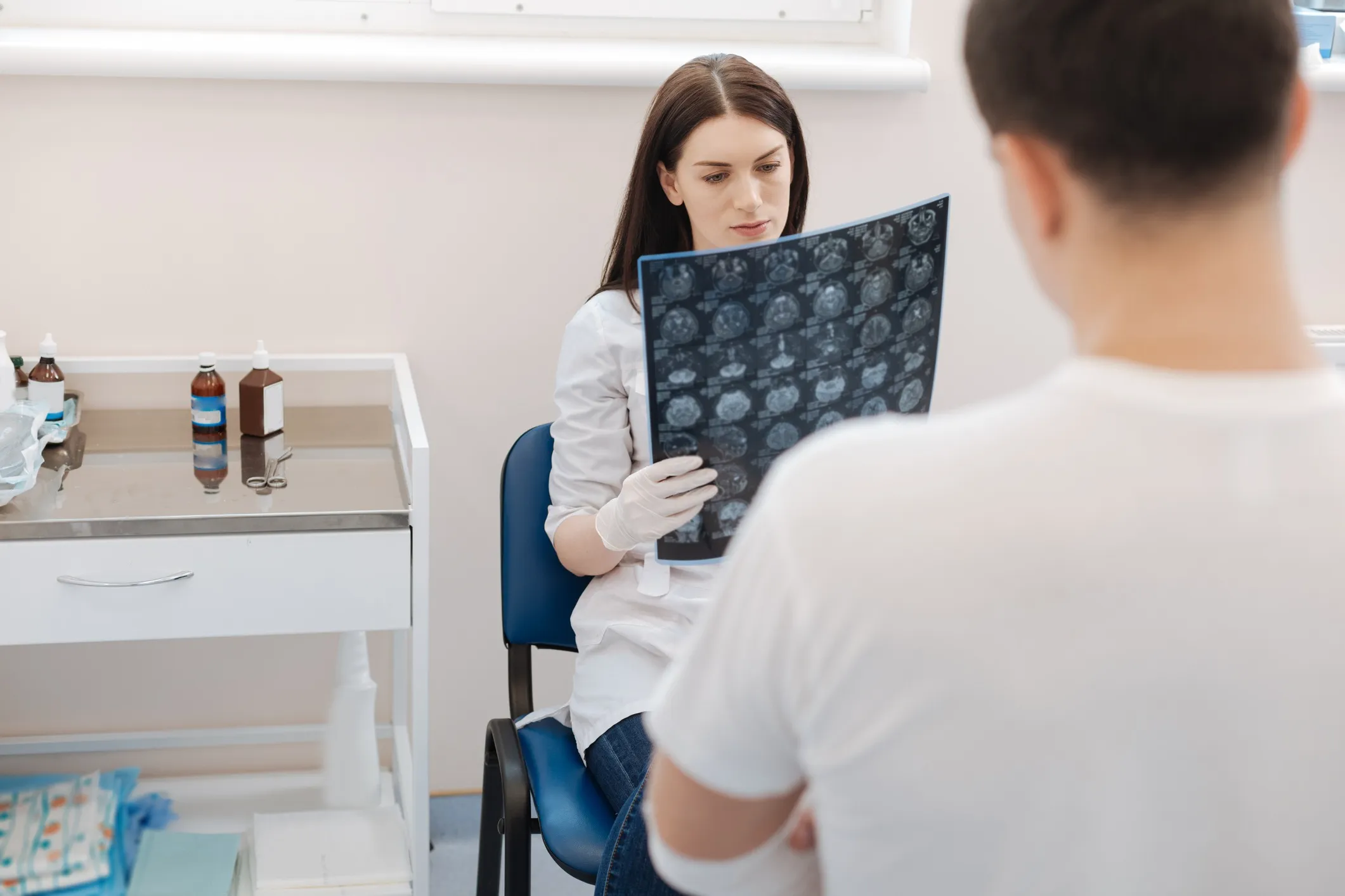 A doctor looking at MRI imaging in front of the patient.